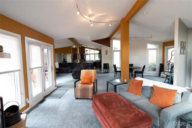Carpeted living room with rail lighting and ceiling fan
