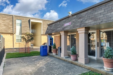Rear view of property with mansard roof and brick siding