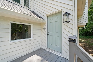 Entrance to property featuring a shingled roof