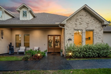 Elegant exterior lighting highlights the architectural lines and mature trees, creating a warm evening welcome.