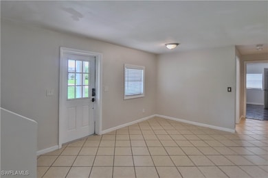 Foyer entrance featuring baseboards and light tile