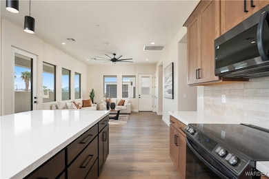 Kitchen with black electric range oven, ceiling fa