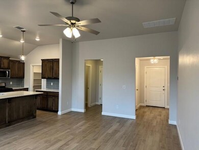 Kitchen featuring dark brown cabinetry, range, lig