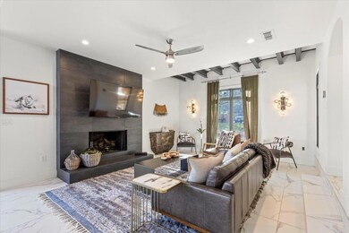 Living area featuring a ceiling fan, marble finis