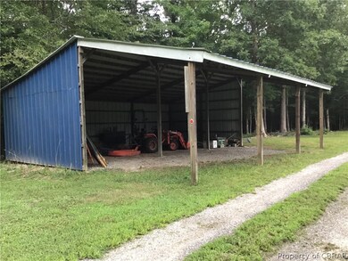 View of outbuilding with a carport and a lawn