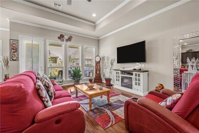 Living area featuring wood finished floors, crown
