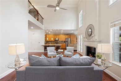 Living area with dark wood-style flooring, baseboards, and crown molding