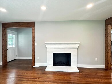 Detailed view of wood finished floors, recessed lighting, baseboards, and a brick fireplace