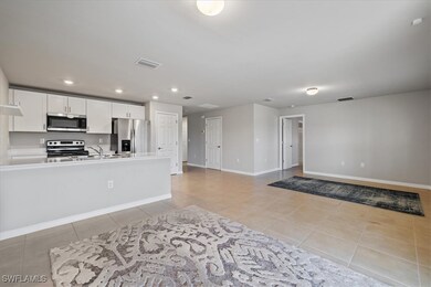 Kitchen featuring visible vents, light tile patterned flooring, stainless steel appliances, white cabinetry, and open floor plan