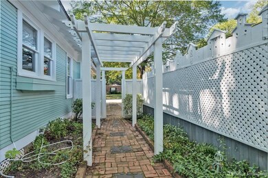 Shaded brick walkway on the side of the home.