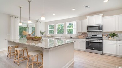 Kitchen featuring white cabinets, light hardwood /