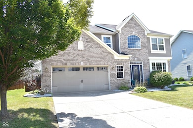 traditional-style home with brick siding, driveway, and an attached garage
