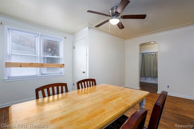Dining space featuring dark wood-style floors, arched walkways, and ceiling fan