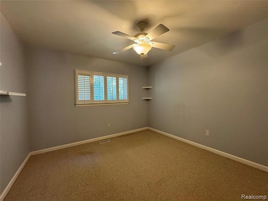 Unfurnished room featuring carpet and ceiling fan