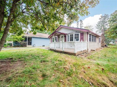 Back of house featuring a lawn and wooden deck