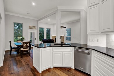 Kitchen with white cabinets, sink, dark hardwood /