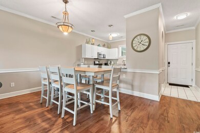 Dining area with crown molding, baseboards, and wo