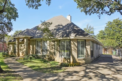 View of front of property featuring a chimney, brick siding, and a shingled roof