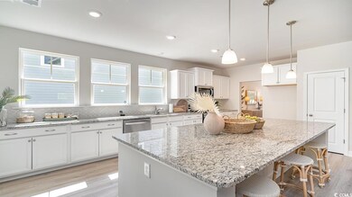Kitchen featuring backsplash, white cabinets, ligh