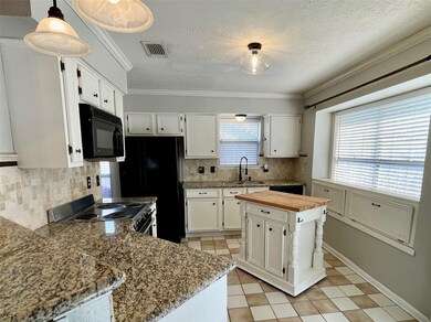 Kitchen features granite countertops, built-in microwave, and island with storage.  Kitchen measures 14' x 10'.