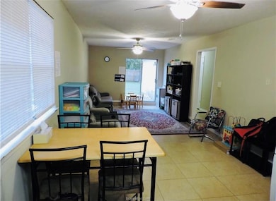 Tiled living area featuring a ceiling fan