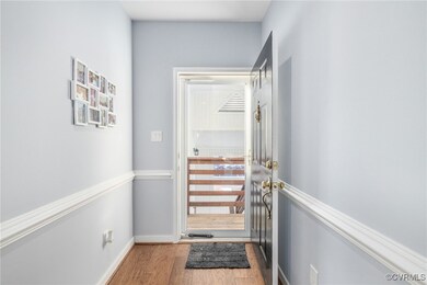 Front Door w/ Storm Door featuring light hardwood