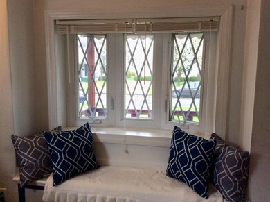 Cozy window seat overlooks front lawn