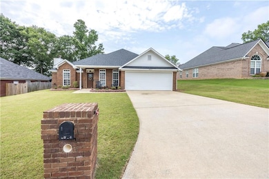 Traditional-style house with brick siding, an attached garage, concrete driveway, roof with shingles, and a chimney