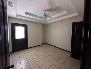 Tiled spare room with a raised ceiling and ceiling fan