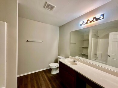 Bathroom with hardwood / wood-style floors, toilet