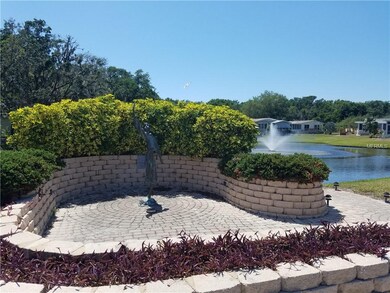 Bronze statue and lake at end of street within wal