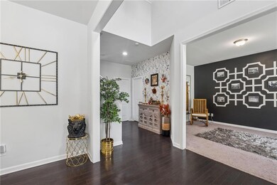 Entryway featuring an accent wall, wood finished floors, baseboards, and wallpapered walls
