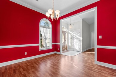 Foyer featuring ornamental molding, wood finished floors, and a chandelier