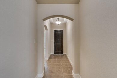 Hall featuring light tile patterned flooring, arch