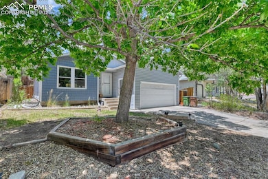 View of property hidden behind natural elements featuring driveway and a garage