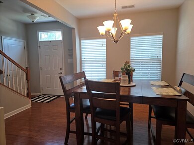 Dining room with wood finished floors, a chandelie