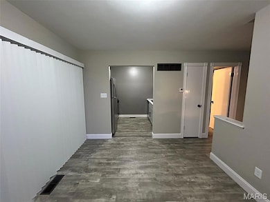 Hall featuring dark wood finished floors and baseboards