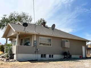 View of side of home featuring a chimney and covered porch