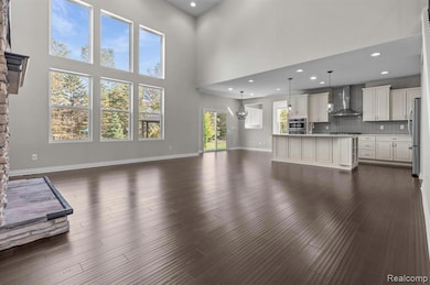Unfurnished living room featuring recessed lighting, a high ceiling, dark wood finished floors, and a fireplace
