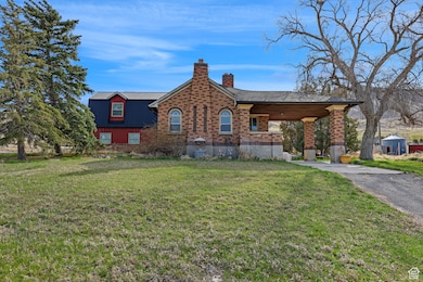 Cabin with a front yard, aphalt driveway, and a chimney