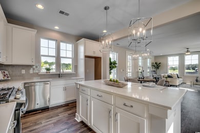 Kitchen with stainless steel dishwasher, range with gas stovetop, open floor plan, dark wood finished floors, and tasteful backsplash