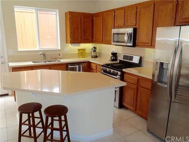 Large kitchen island with new quartz counter and stainless appliances
