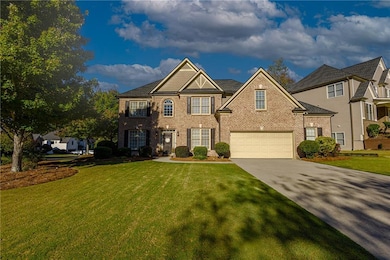 View of front of home featuring brick siding, driveway, and a front lawn