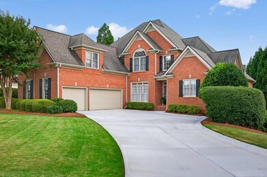 View of front of house featuring brick siding, concrete driveway, a front lawn, roof with shingles, and a garage