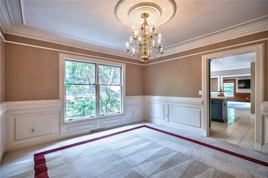 Formal dining room off kitchen offers additional seating for guests and entertaining