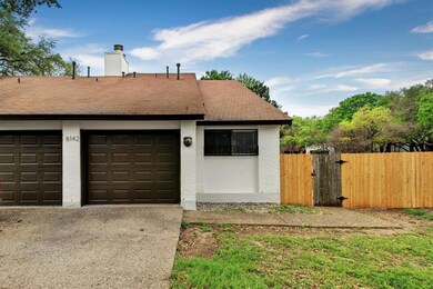 Garage featuring fence, a gate, and concrete driv
