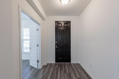 Entryway featuring baseboards and dark wood-style