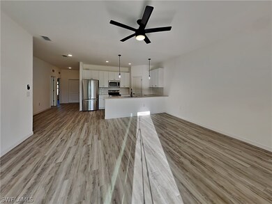 This is a picture of a previously completed home. Unfurnished living room with sink, light hardwood / wood-style flooring, and ceiling fan