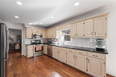Kitchen with dark wood-style flooring, crown moldi