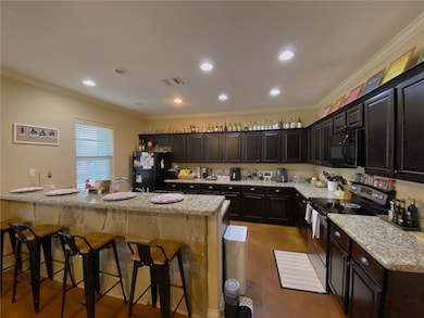Kitchen featuring black appliances, a breakfast ba